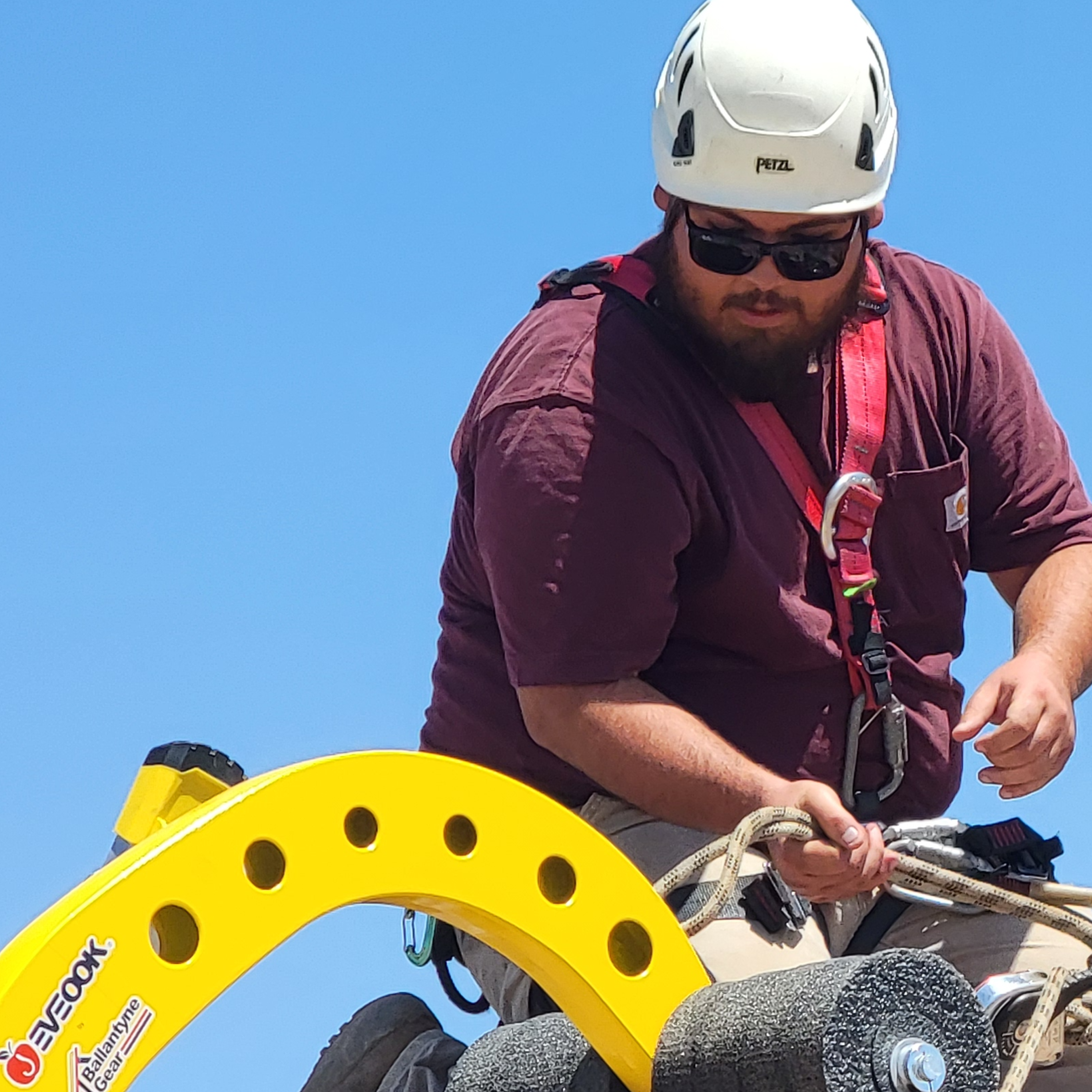 sloped roof worker wearing a roof harness, helmet, and PPE using the Eveook Fall Protection System for sloped roofs