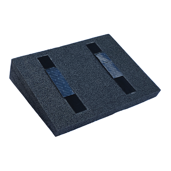 Black foam block with two rectangular cutouts on a white background