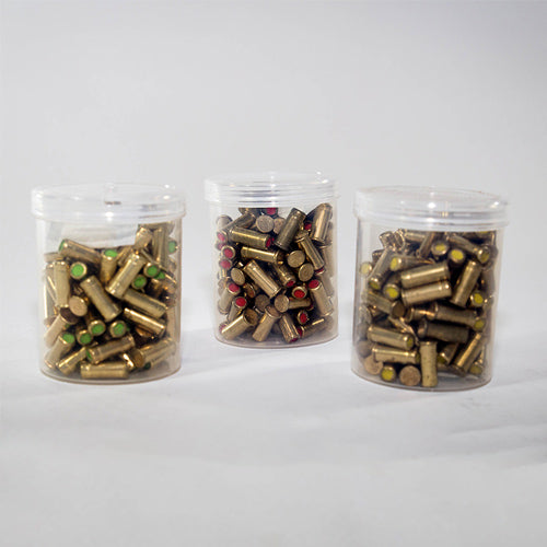 A set of .22 blank cartridges in a clear plastic container, with cartridges displaying various colors such as red, green, and yellow.