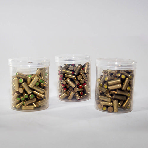 Three clear plastic containers filled with yellow blank cartridges for line-launcher use with roofing fall protection