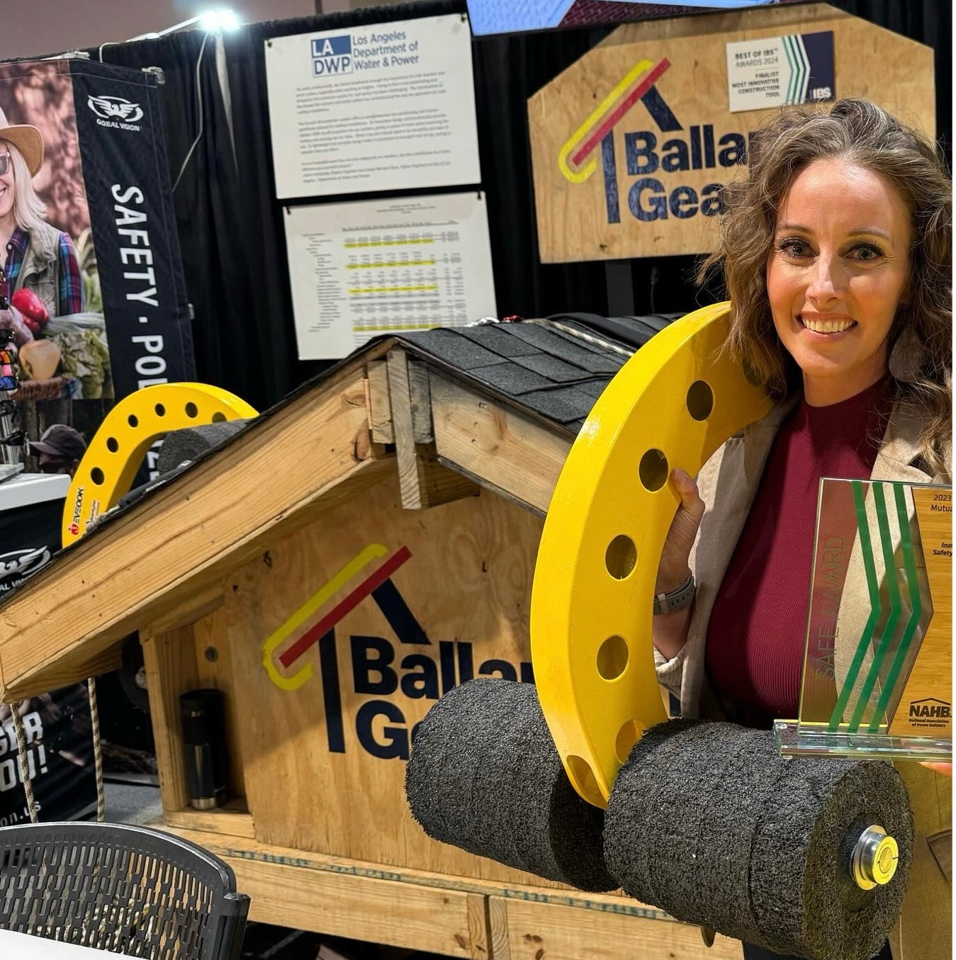 Eveook booth at tradeshow and woman holding Job-Site Safety Award and Eveook on shoulder 