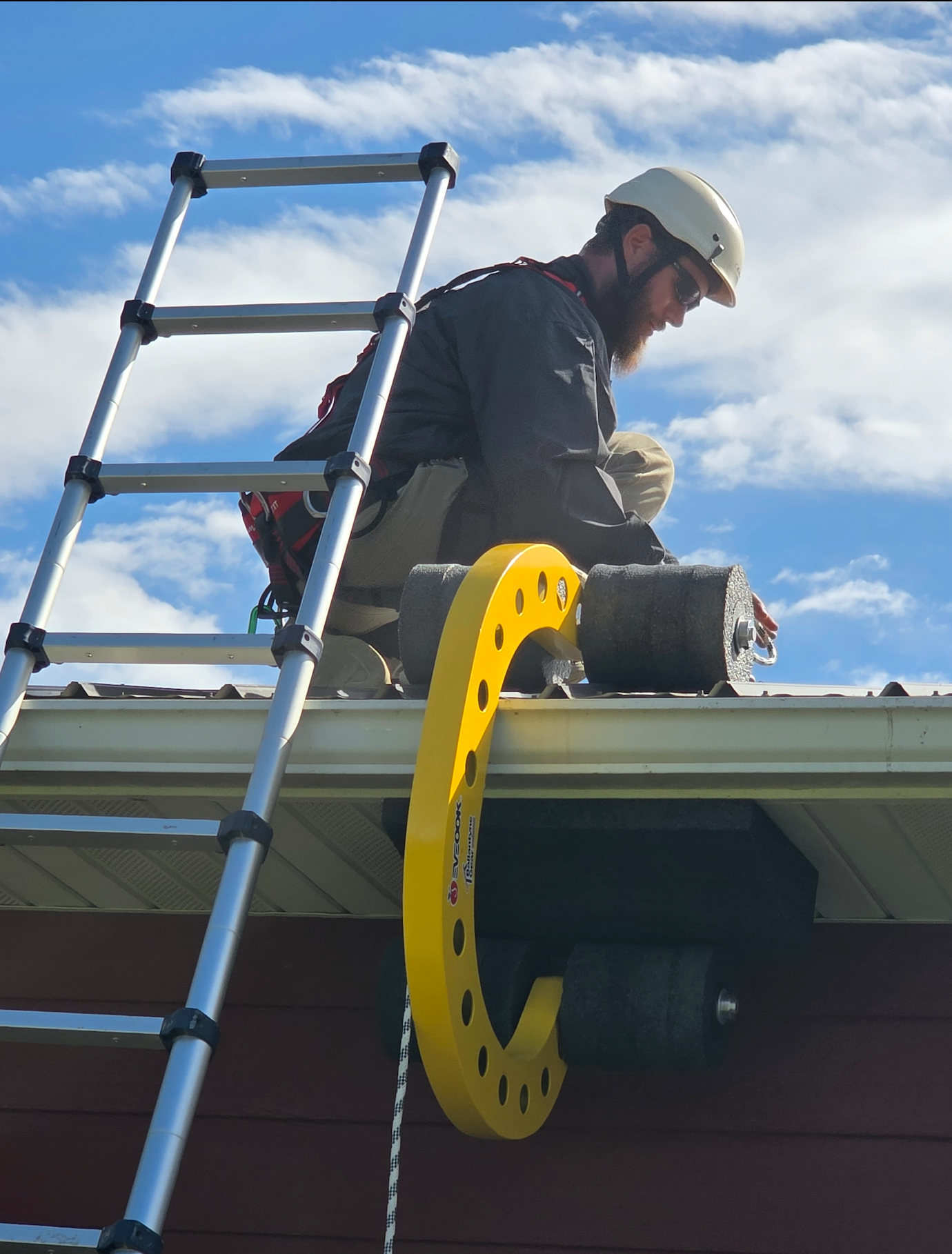 Roof worker doing pest control installing an Eveook Fall Protection System with Soffit Wedge