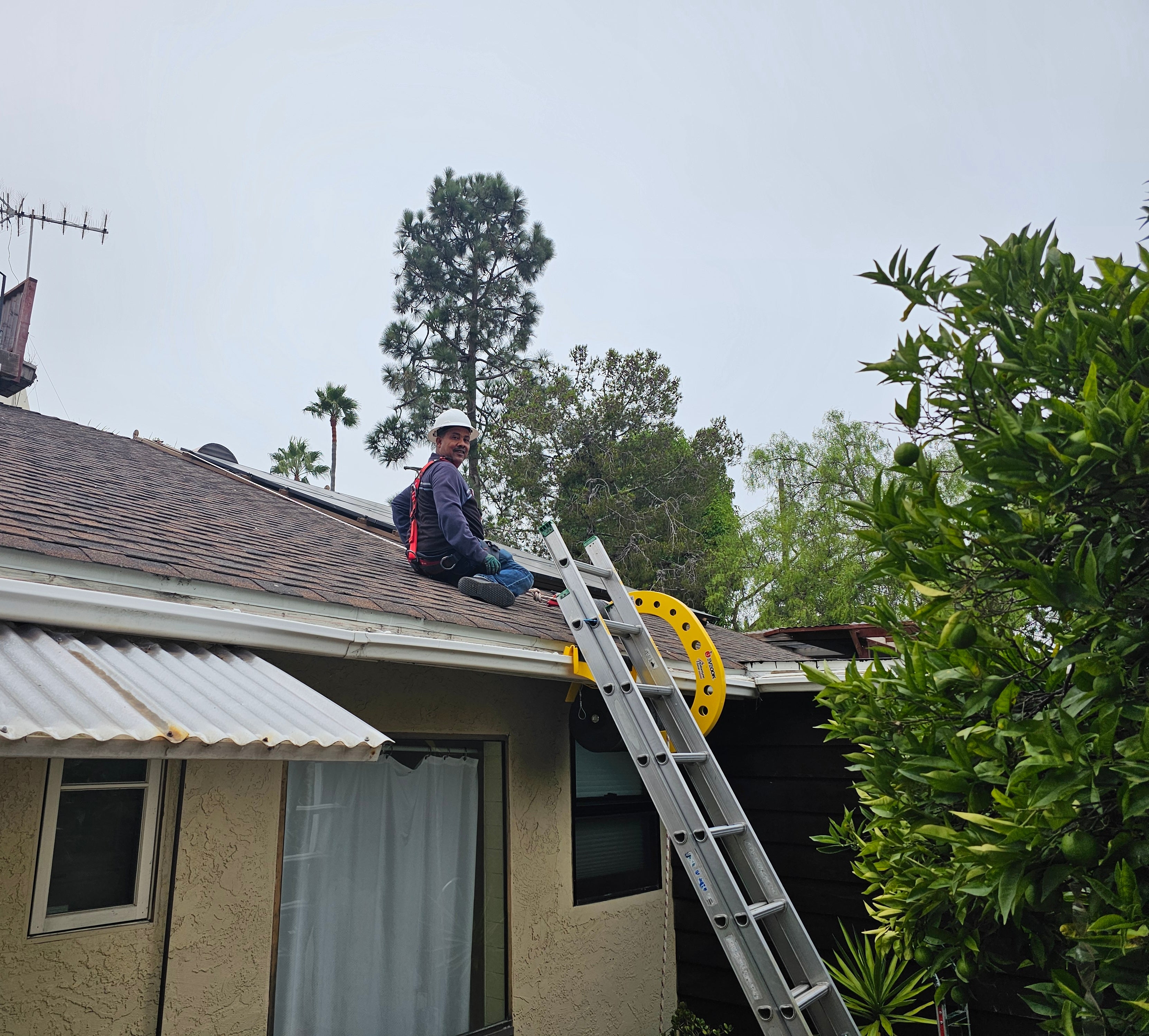 happy roof worker wearing fall protection and roof harness PPE using Eveook system 