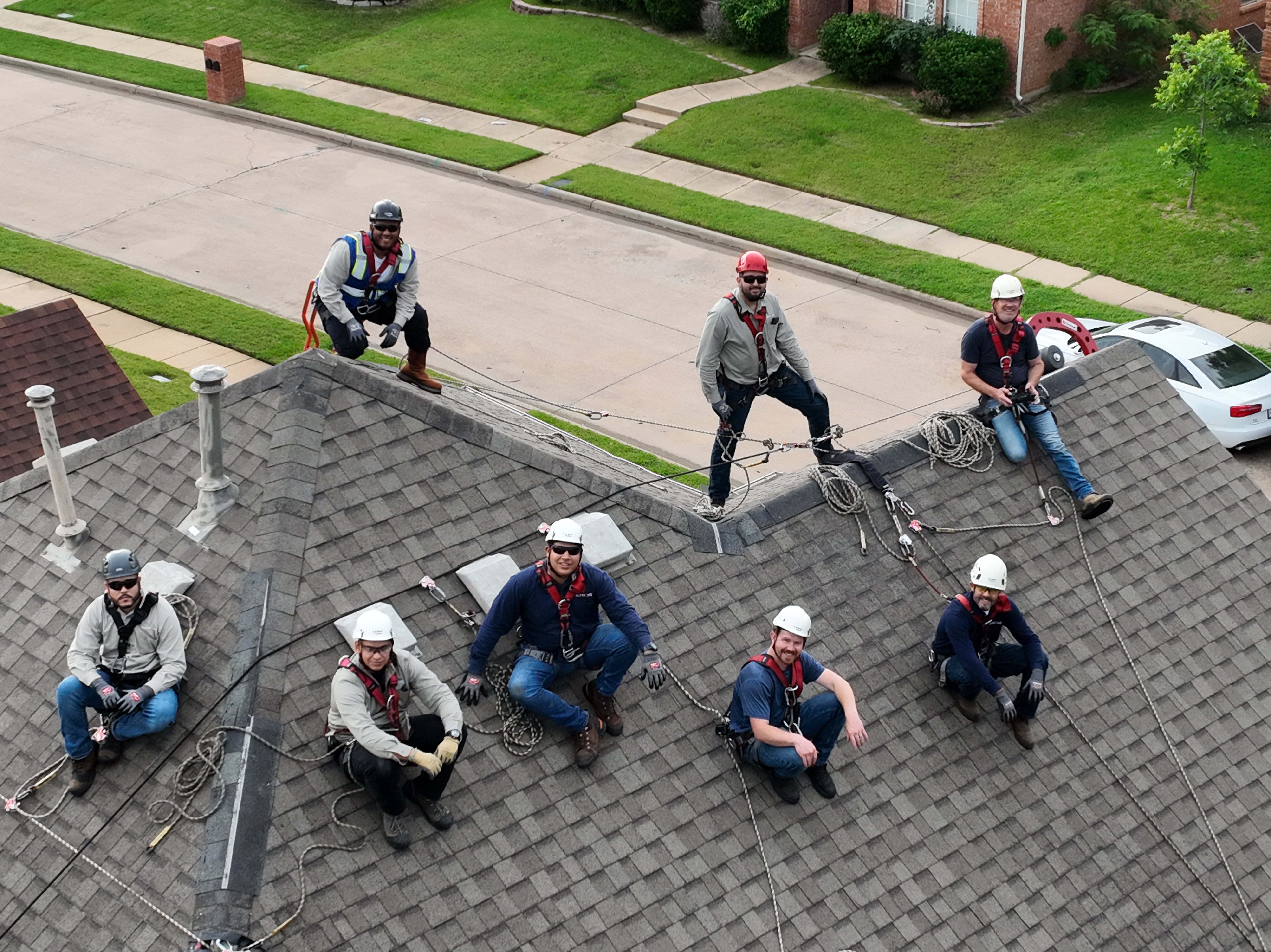 Roofing crew of solar workers using non-penetrating roof anchor Eveook roof safety system