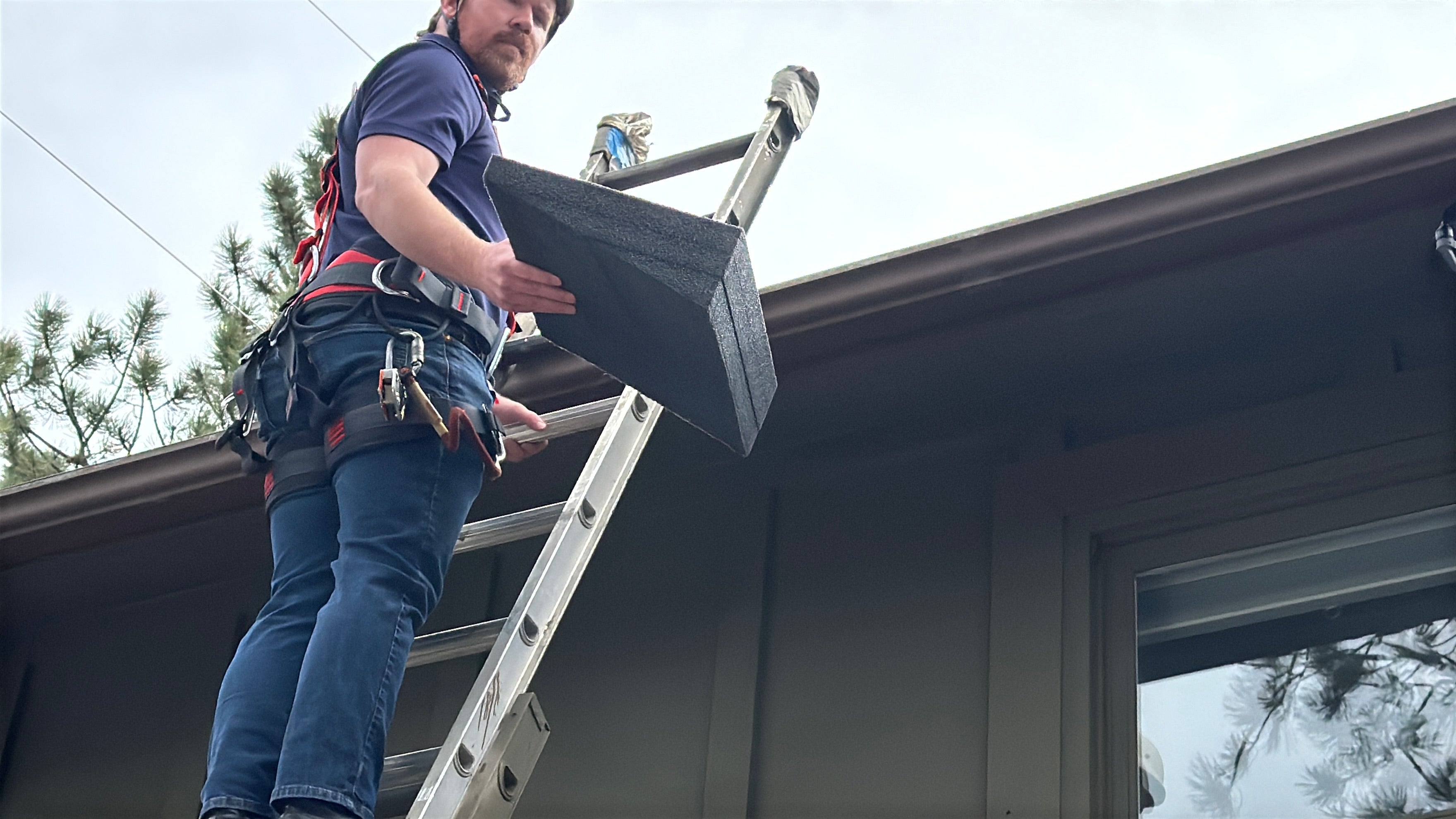 Person on a ladder working on a roof