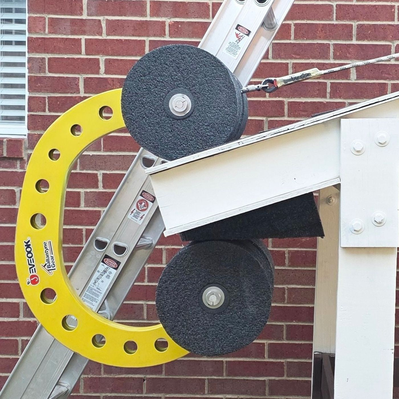 Ladder in the back with SoffitWedge on a sloped structure in front of  a brick wall