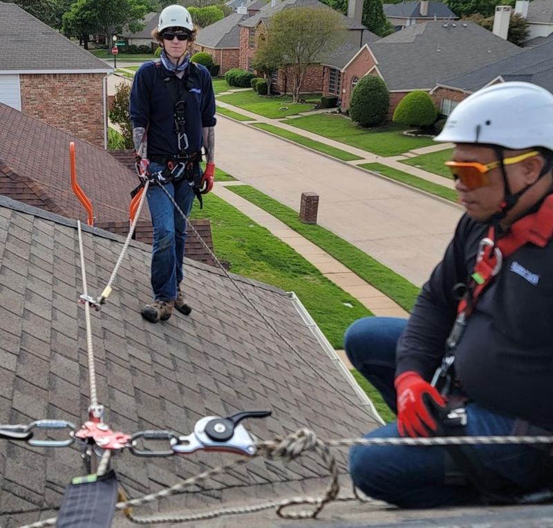 Two workers on a roof using Eveook fall protection roof safety equipment, a CAMP Goblin and PPE  on a sloped roof 